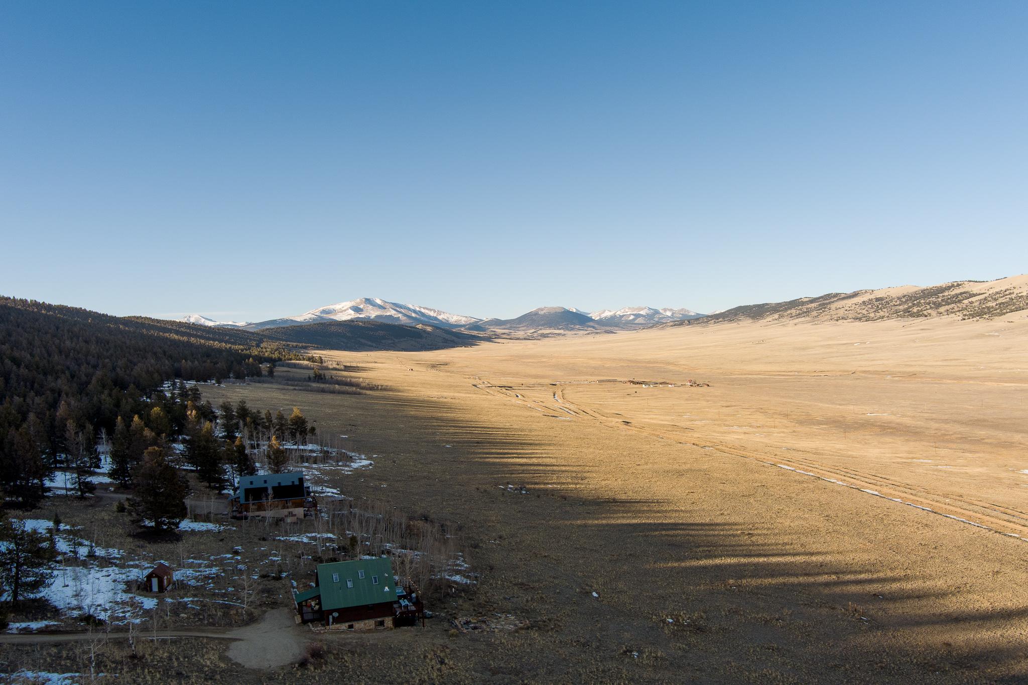 Golden-hour aerial view of Skyfall Chalet with the snow-capped range behind