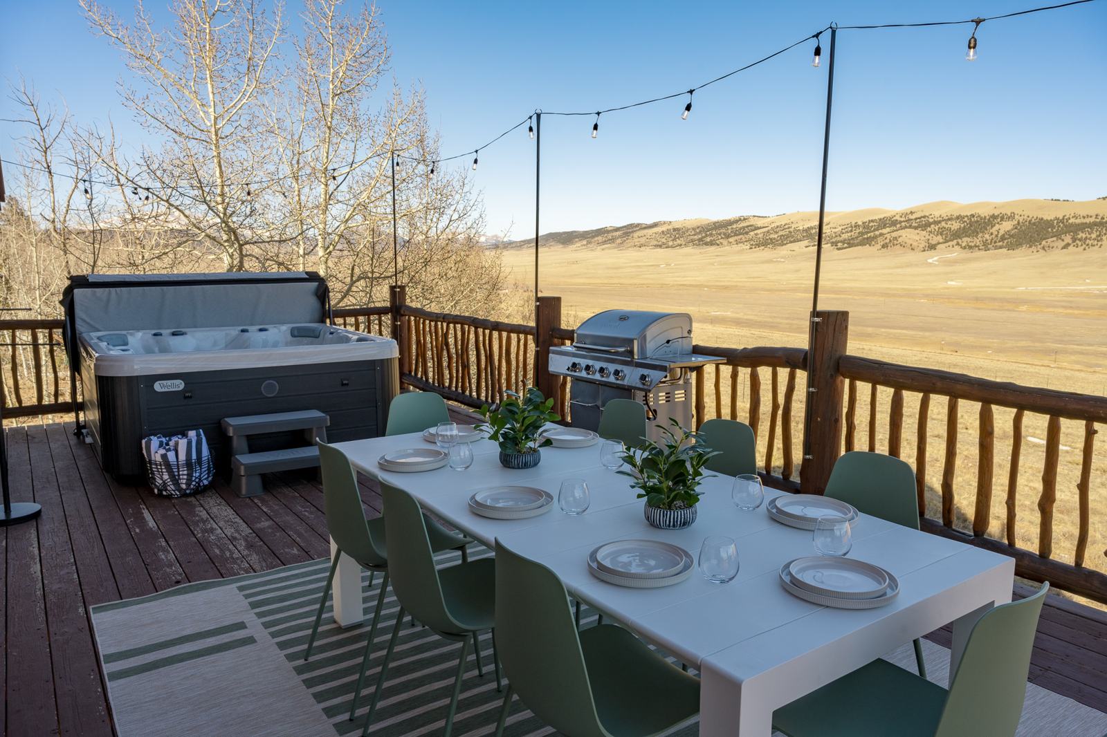 Deck with outdoor dining table, open hot tub, grill and endless valley view