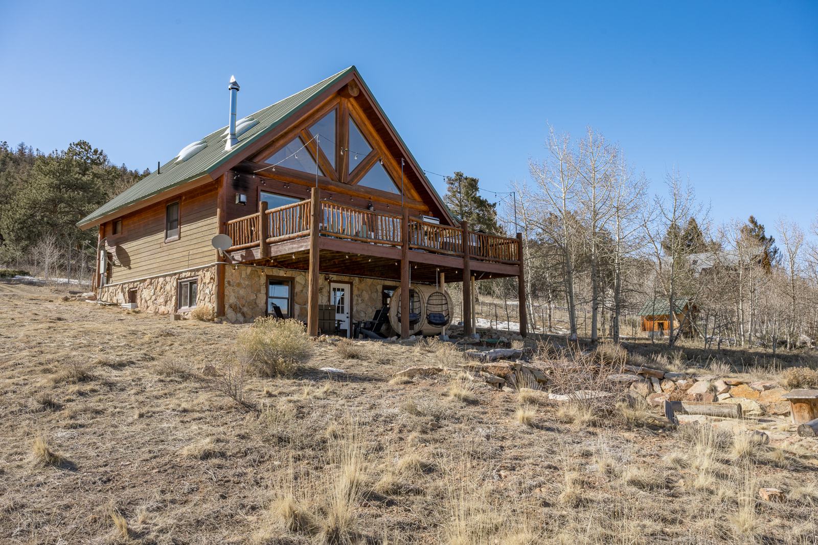 Chalet exterior with prow glass gable, wraparound deck and barrel sauna below