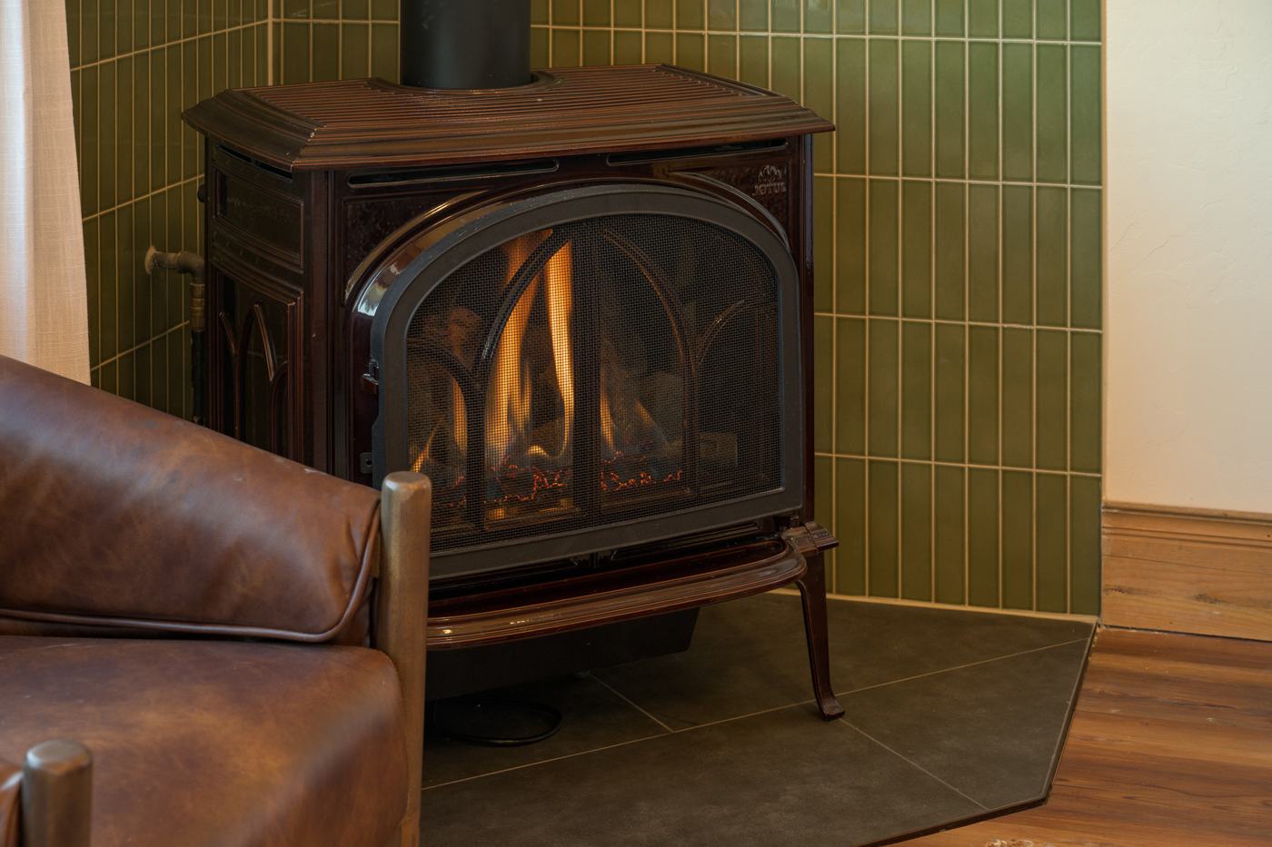 Jotul gas stove with olive green tile surround