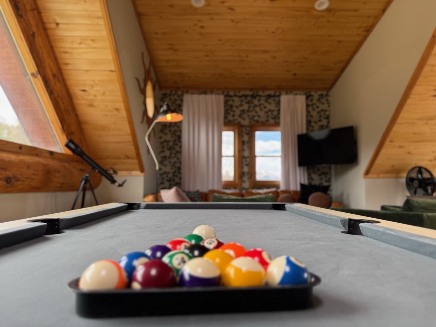 Loft game room with pool table, telescope and lounge seating