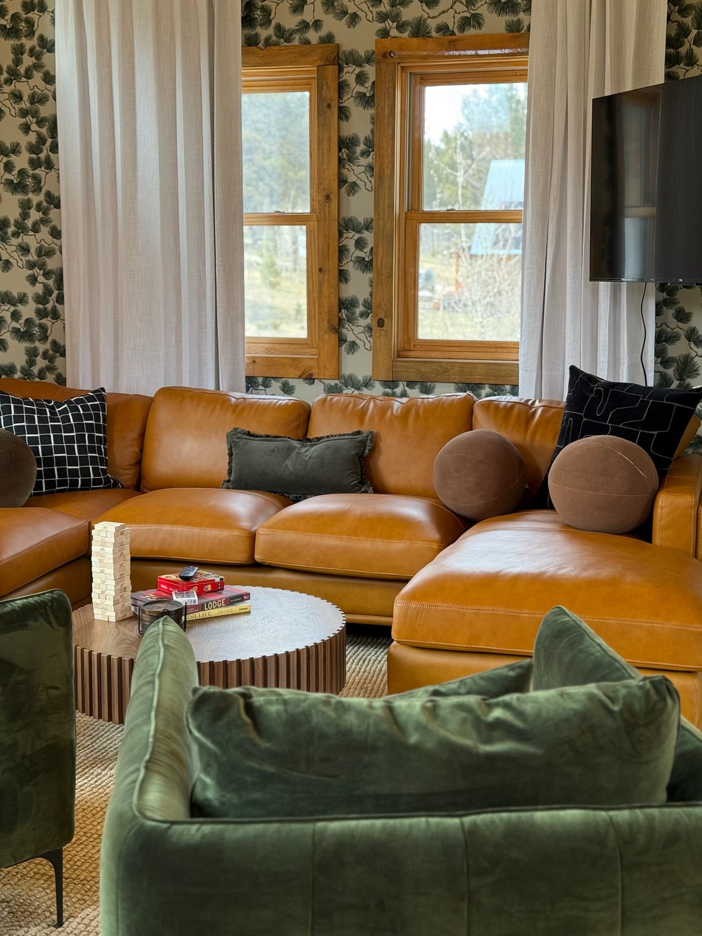 Upstairs game loft lounge with leather sectional and green velvet chairs