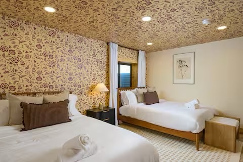 Twin bedroom with floral wallpaper perfect for families